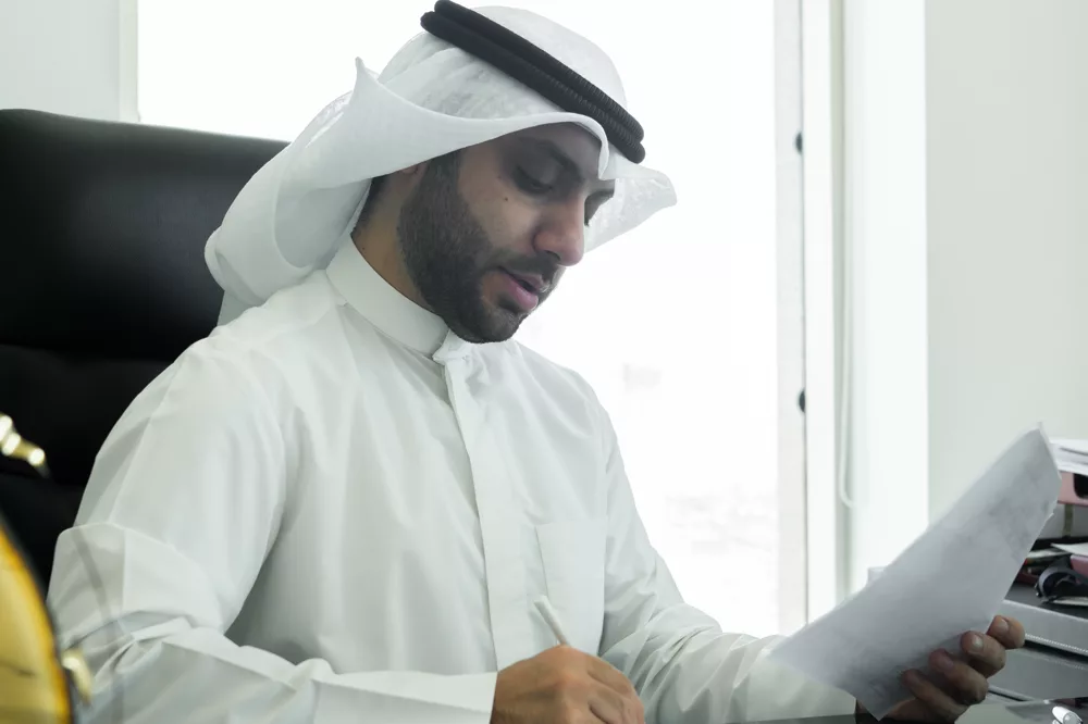 Abdullah Benayan reviewing documents at his desk