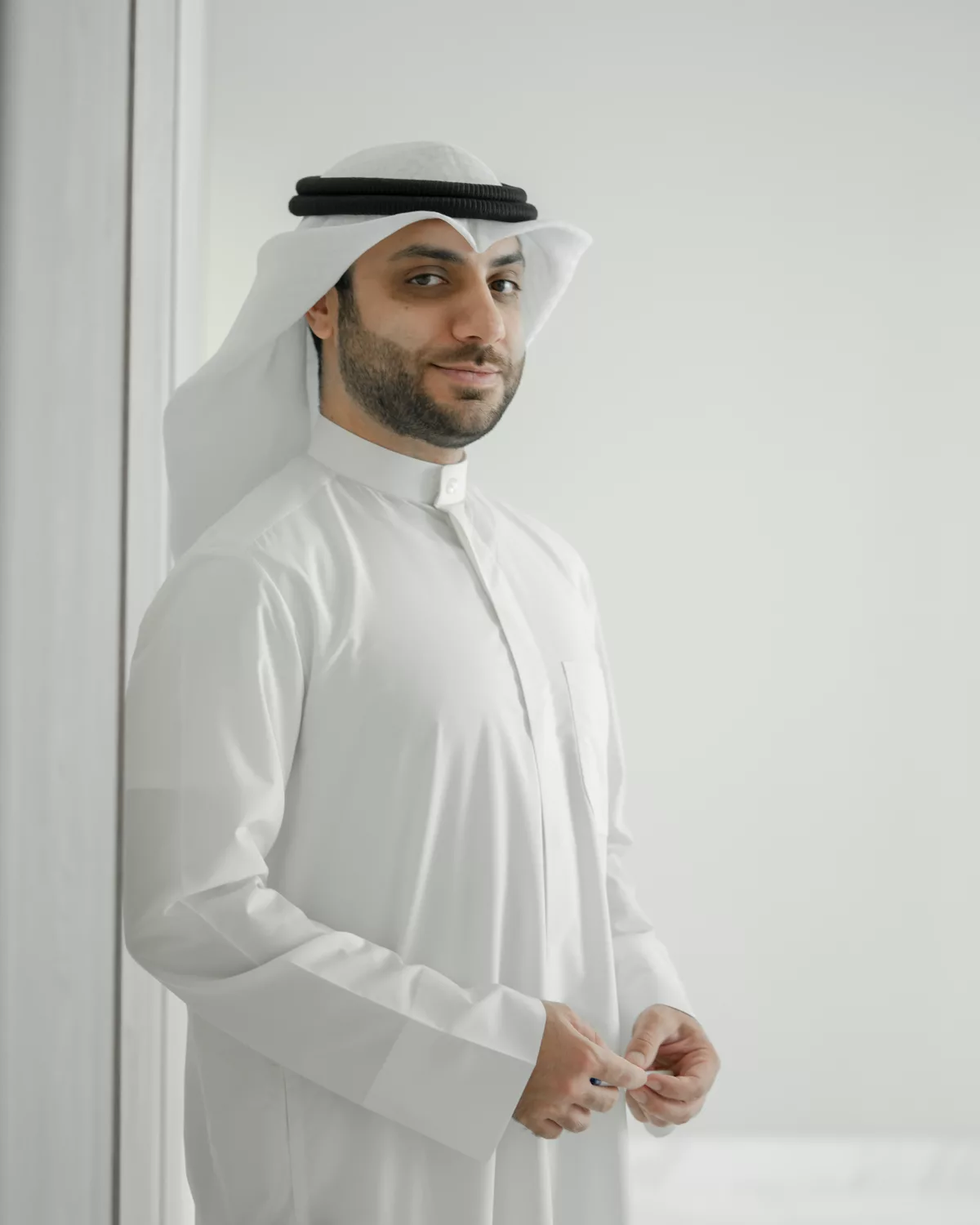 عبدالله بنيان واقفاً بجانب نافذة بإضاءة طبيعية